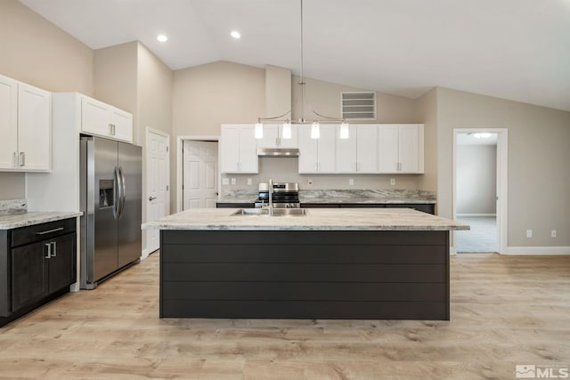 kitchen with under cabinet range hood, visible vents, stainless steel fridge, high vaulted ceiling, and white cabinetry