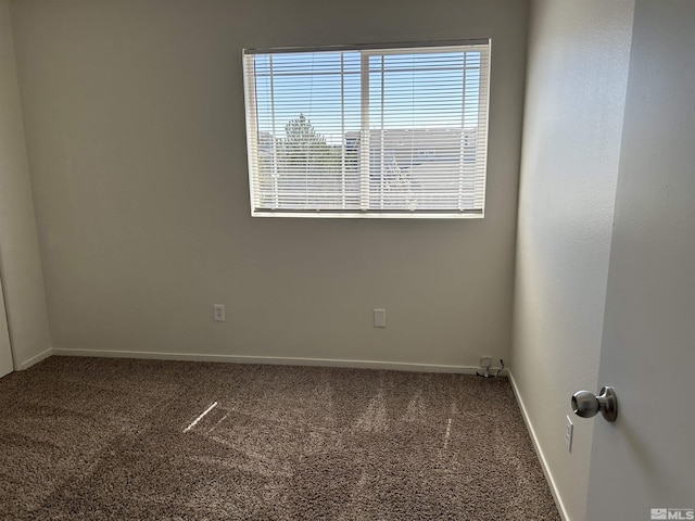 carpeted spare room with baseboards