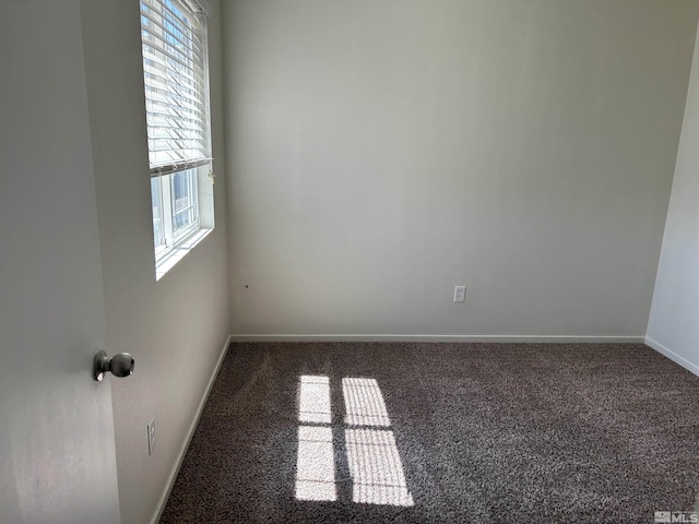 carpeted spare room featuring baseboards