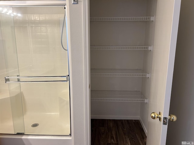interior space with wood finished floors and a stall shower