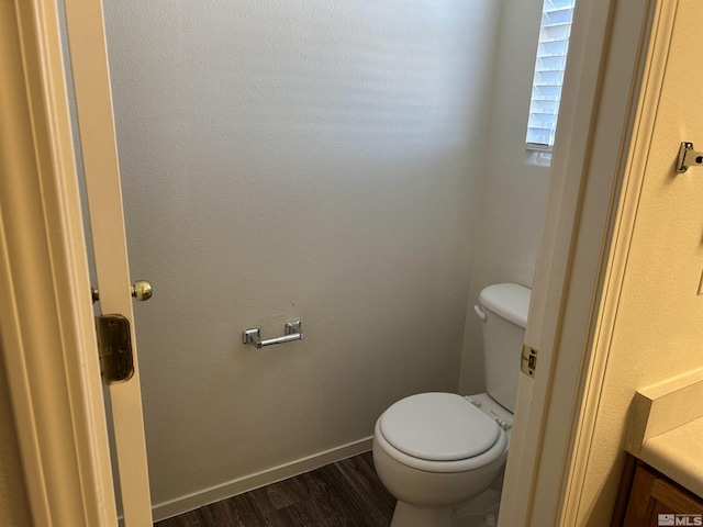 bathroom featuring toilet, vanity, and wood finished floors