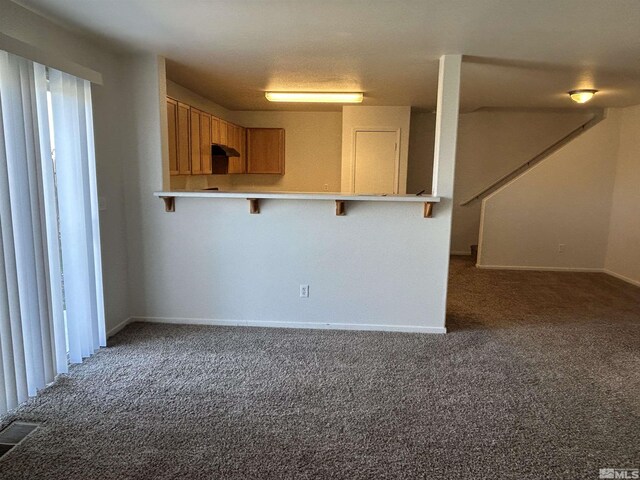 interior space featuring baseboards, visible vents, and carpet
