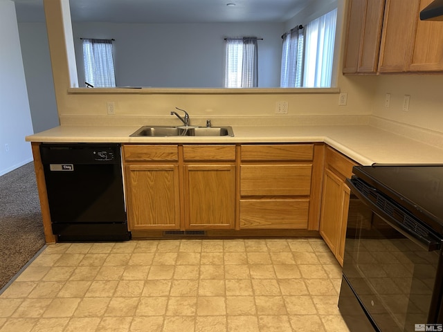 kitchen featuring exhaust hood, light countertops, visible vents, a sink, and black appliances