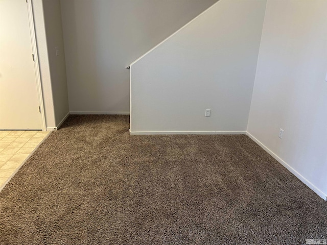 empty room with baseboards and carpet