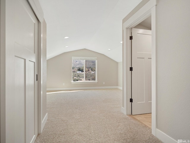 hallway featuring light carpet, vaulted ceiling, baseboards, and recessed lighting