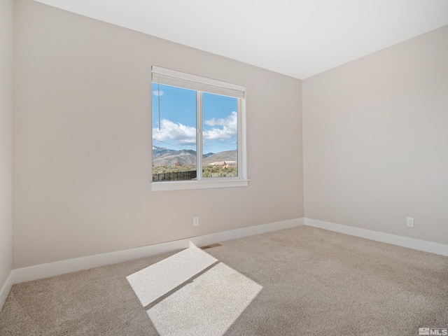 carpeted empty room featuring baseboards and visible vents