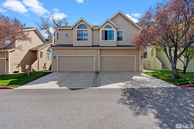 townhome / multi-family property featuring concrete driveway, an attached garage, and stairway