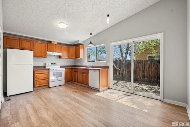 kitchen featuring a textured ceiling, visible vents, lofted ceiling, white appliances, and brown cabinets