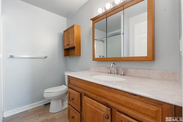 full bath with wood finished floors, visible vents, toilet, vanity, and baseboards