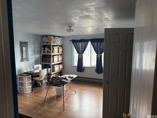 office area with a baseboard radiator and wood finished floors