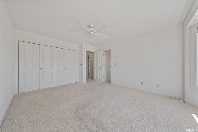 unfurnished bedroom featuring carpet, a closet, baseboards, and ceiling fan