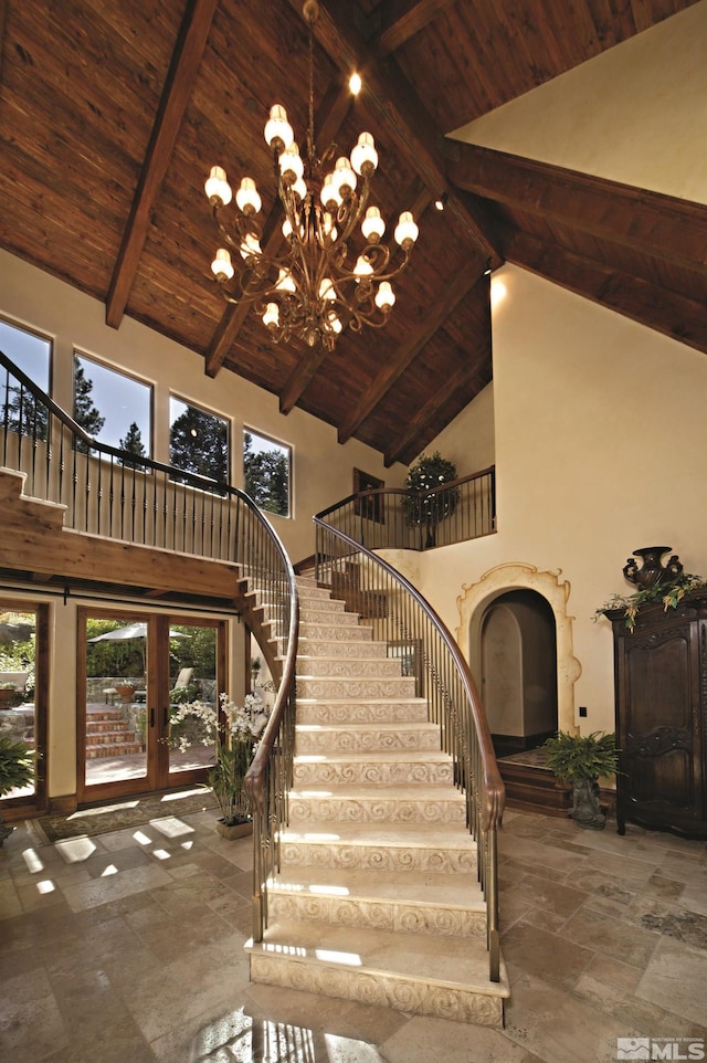 stairway with high vaulted ceiling, beamed ceiling, a notable chandelier, and wooden ceiling