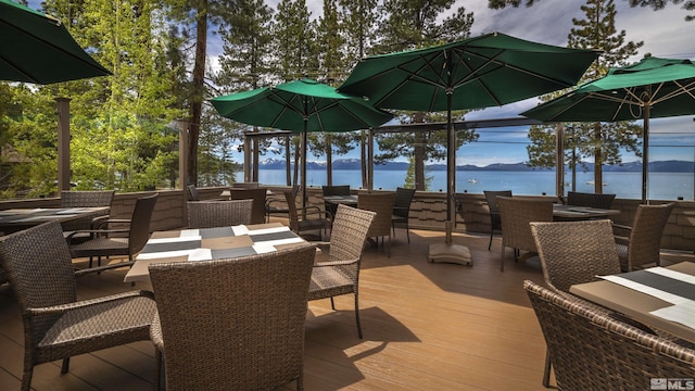 wooden deck with outdoor dining space and a water view