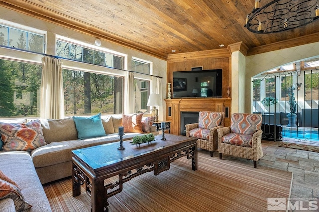 living area with stone tile floors, ornamental molding, a wealth of natural light, and wood ceiling