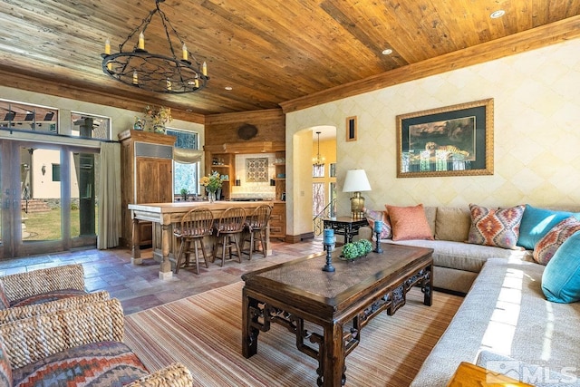 living area featuring wooden ceiling, stone tile flooring, ornamental molding, arched walkways, and wallpapered walls
