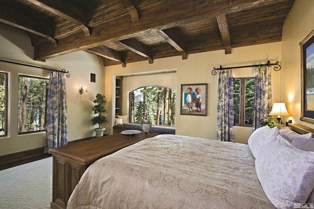 carpeted bedroom featuring beamed ceiling, multiple windows, and wood ceiling