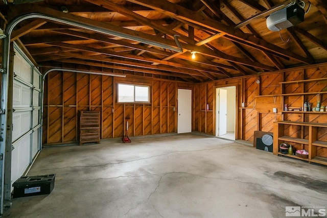 garage with a garage door opener and wooden walls