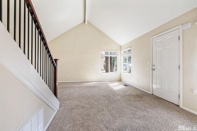 unfurnished living room featuring baseboards, visible vents, beamed ceiling, and carpet