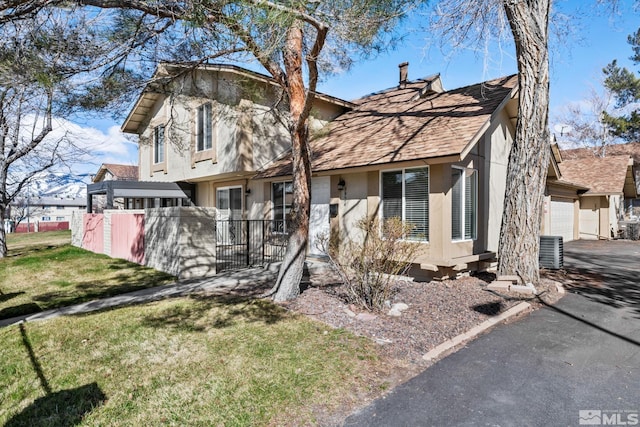 view of front of home with aphalt driveway, cooling unit, fence, a garage, and stucco siding