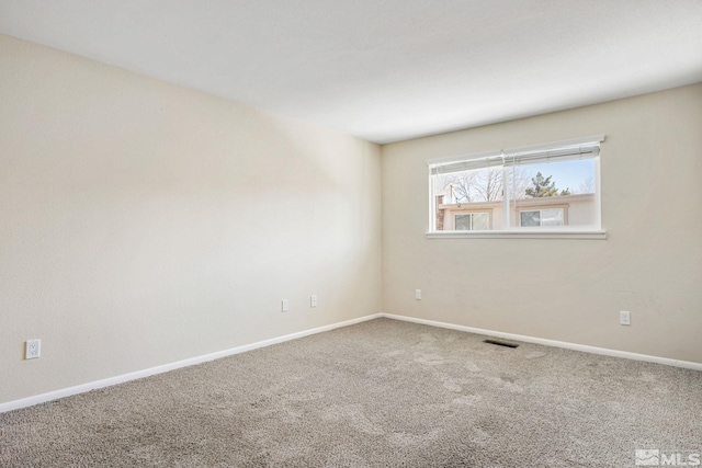spare room featuring visible vents, baseboards, and carpet flooring