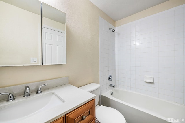full bath with toilet, shower / bathtub combination, vanity, and a textured wall