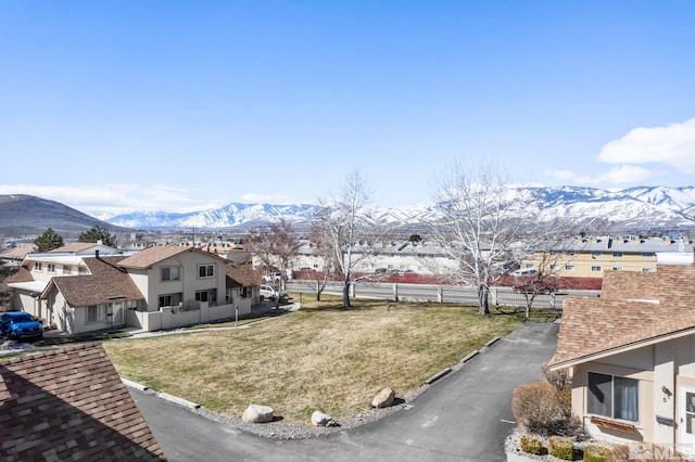 view of yard with fence, a residential view, and a mountain view