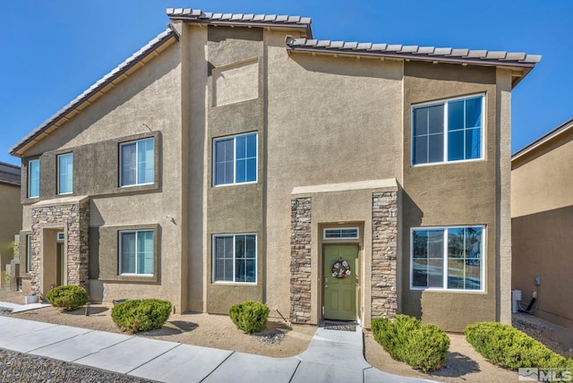 multi unit property featuring stucco siding and stone siding