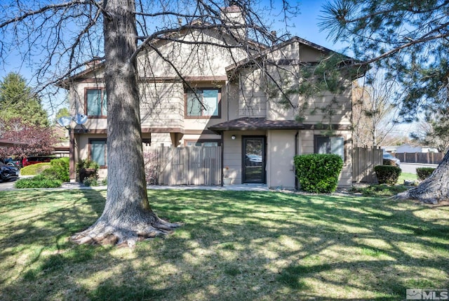 view of front of property with stucco siding, fence, and a front yard