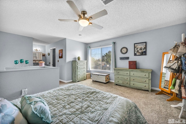 bedroom featuring a ceiling fan, a textured ceiling, carpet, baseboards, and visible vents