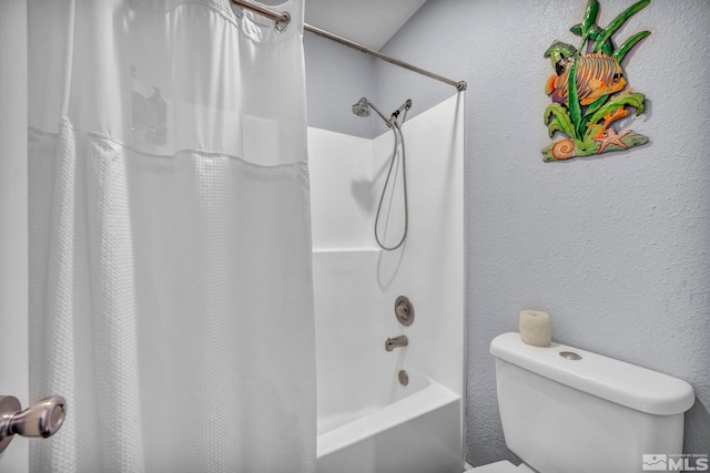 bathroom featuring a textured wall, shower / bath combo, and toilet