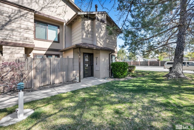 view of front of house with a front lawn and fence
