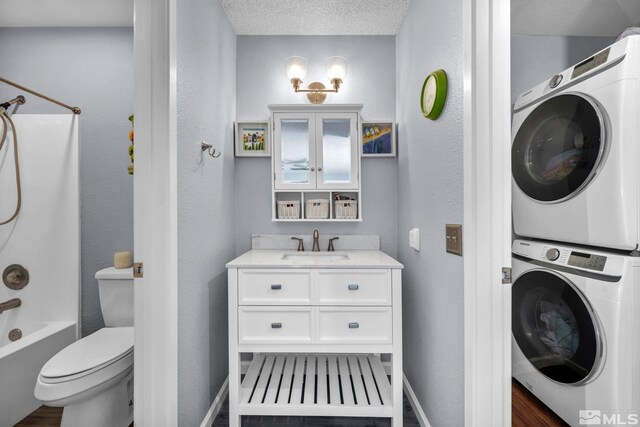 bathroom featuring shower / washtub combination, baseboards, stacked washer / dryer, and toilet