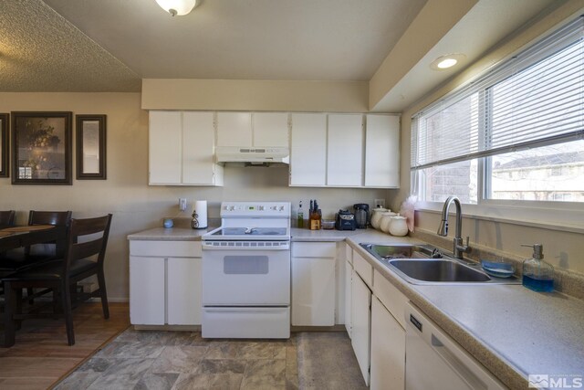 kitchen with a sink, white cabinetry, white appliances, light countertops, and under cabinet range hood
