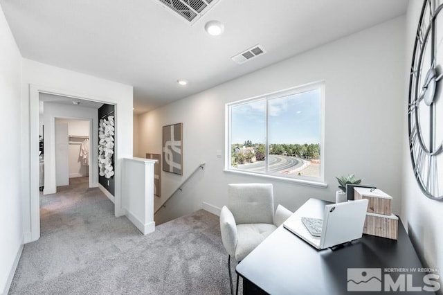 office with visible vents, baseboards, and light carpet
