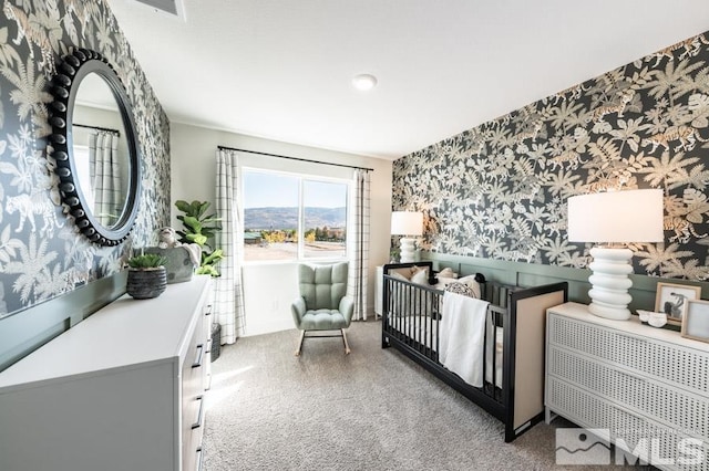 carpeted bedroom featuring a wainscoted wall and wallpapered walls