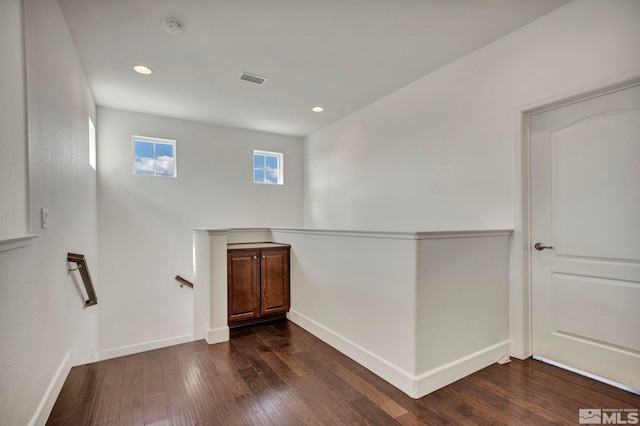 interior space featuring baseboards, recessed lighting, an upstairs landing, and dark wood-style flooring