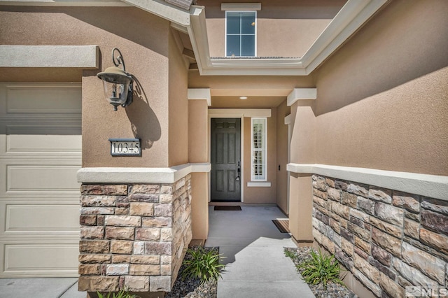 view of exterior entry with stone siding and stucco siding