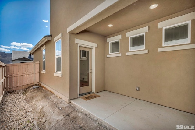 exterior space featuring fence, a patio area, and stucco siding