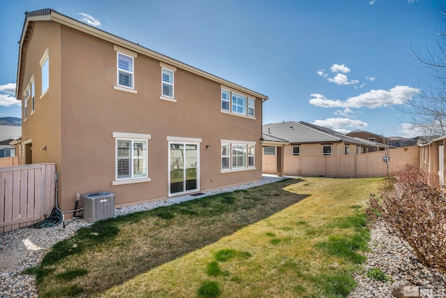 rear view of house featuring central air condition unit, a lawn, a fenced backyard, and stucco siding