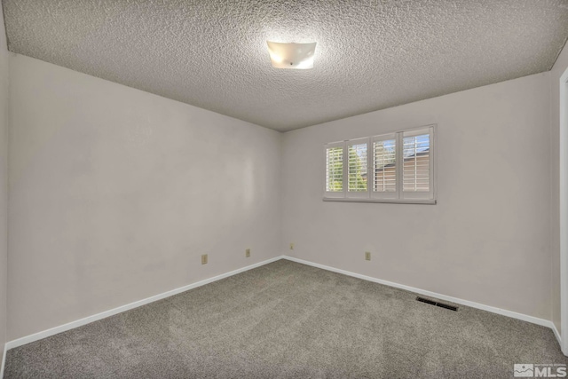 unfurnished room featuring baseboards, carpet flooring, a textured ceiling, and visible vents