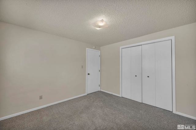 unfurnished bedroom with baseboards, carpet, a textured ceiling, and a closet