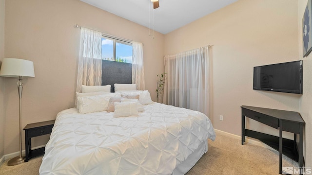 carpeted bedroom with a ceiling fan and baseboards