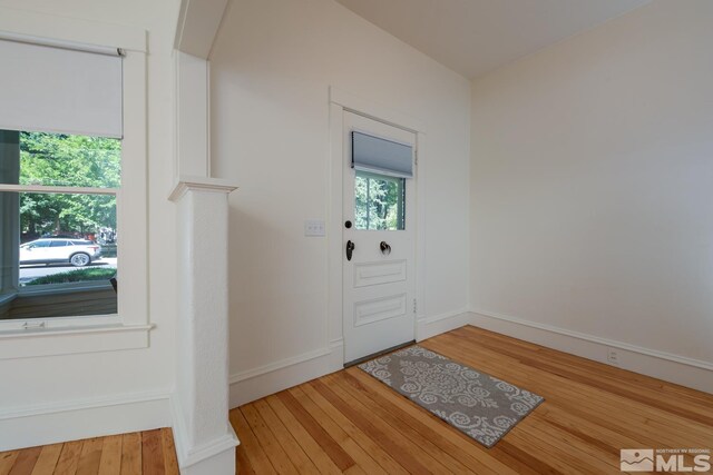 doorway with baseboards and wood-type flooring