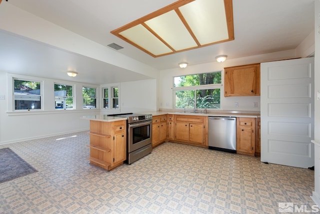kitchen with stainless steel appliances, a peninsula, visible vents, open shelves, and light countertops