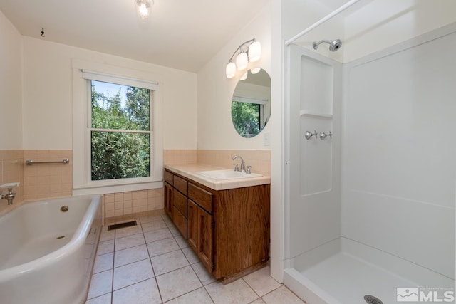 bathroom featuring tile patterned flooring, visible vents, vanity, a garden tub, and a stall shower