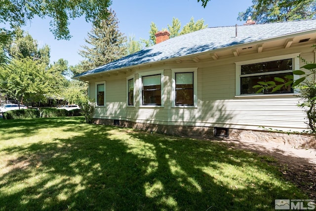 back of house with a lawn and a chimney