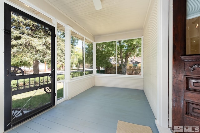 unfurnished sunroom with ceiling fan