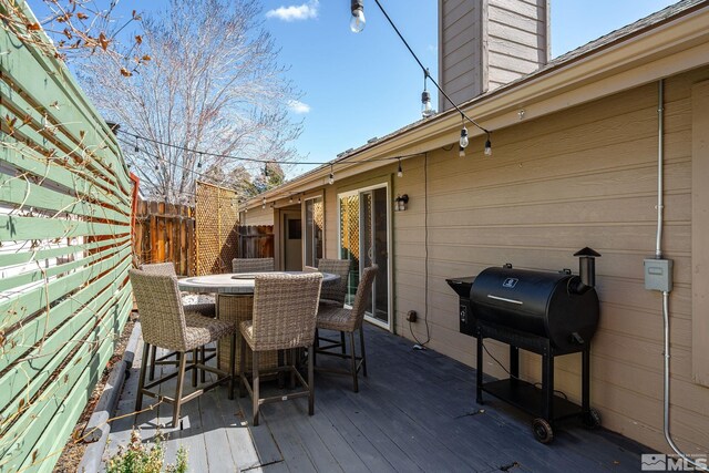 deck featuring outdoor dining area, fence, and area for grilling