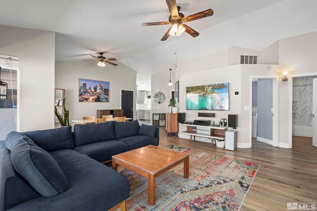 living room featuring high vaulted ceiling, a ceiling fan, wood finished floors, baseboards, and visible vents