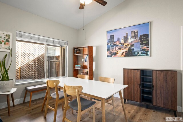 dining area with lofted ceiling, wood finished floors, baseboards, and ceiling fan